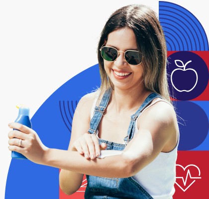 A woman putting sunscreen on her arm.