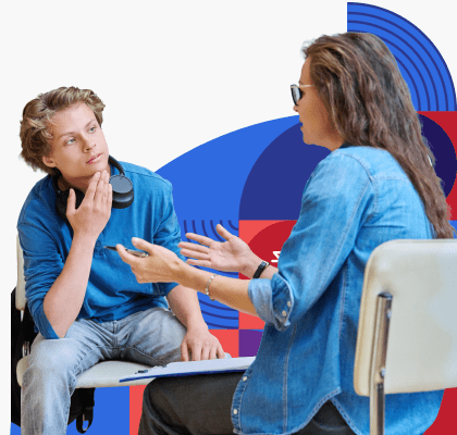 A woman sits across from and speaks with a teenage boy.