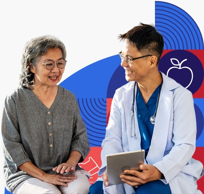 An older Asian woman reviews information on a tablet with a male provider wearing a white coat.