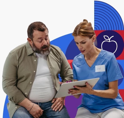 A white man reviews information on a clipboard with a young female provider.