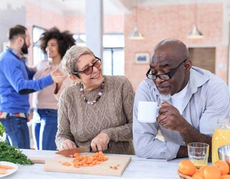 Couple having coffee and preparing food together.