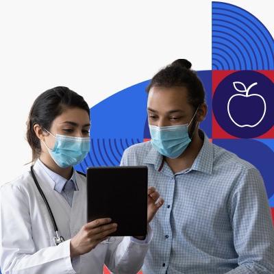 Una profesional de la salud habla con un paciente, un hombre joven hispano. Ambos están usando mascarillas.