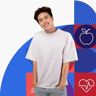 A smiling young person wearing a baggy t-shirt with their hands in their pants pockets. 