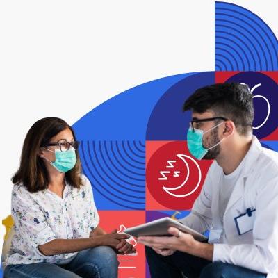 Un doctor conversa con una paciente. Ambos están usando mascarillas.