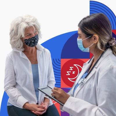 A doctor wearing a face mask takes notes while talking with a masked patient.