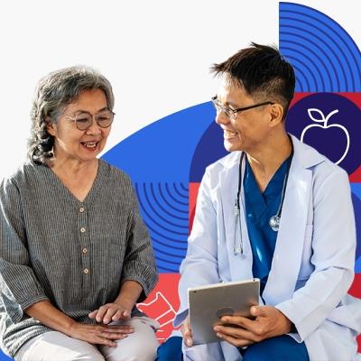 An older Asian woman reviews information on a tablet with a male provider wearing a white coat.