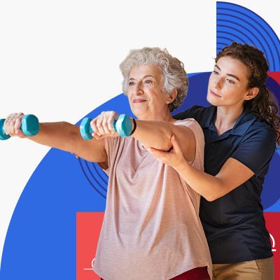 An older woman lifts dumbbells while a health care provider supports her arms.