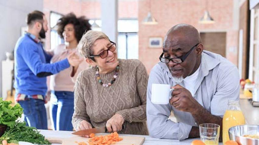Couple having coffee and preparing food together.