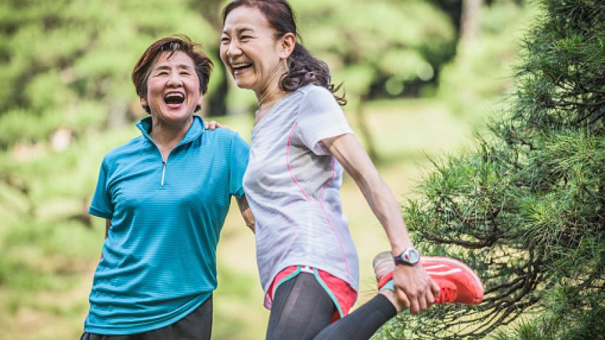 Mother and daughter stretching outside and enjoying themselves.