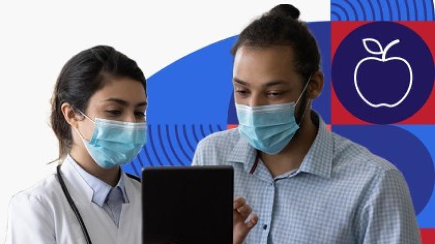 Una profesional de la salud habla con un paciente, un hombre joven hispano. Ambos están usando mascarillas.