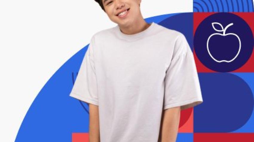 A smiling young person wearing a baggy t-shirt with their hands in their pants pockets. 