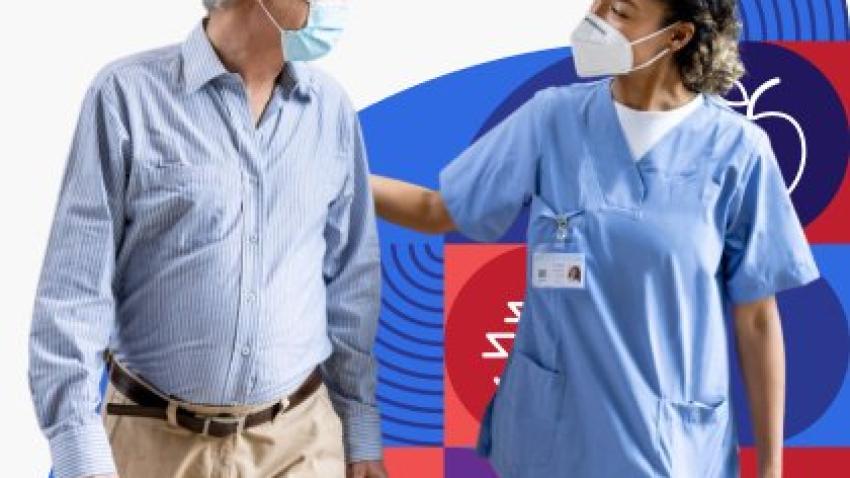A medical professional is wearing a face mask and putting their hand on the back of a patient who is also wearing a face mask. 